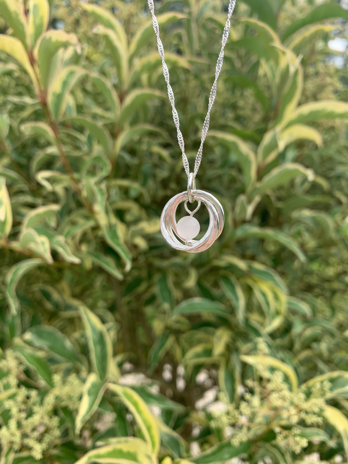 handmade sterling silver hammered three ring pendant with rose quartz gemstone