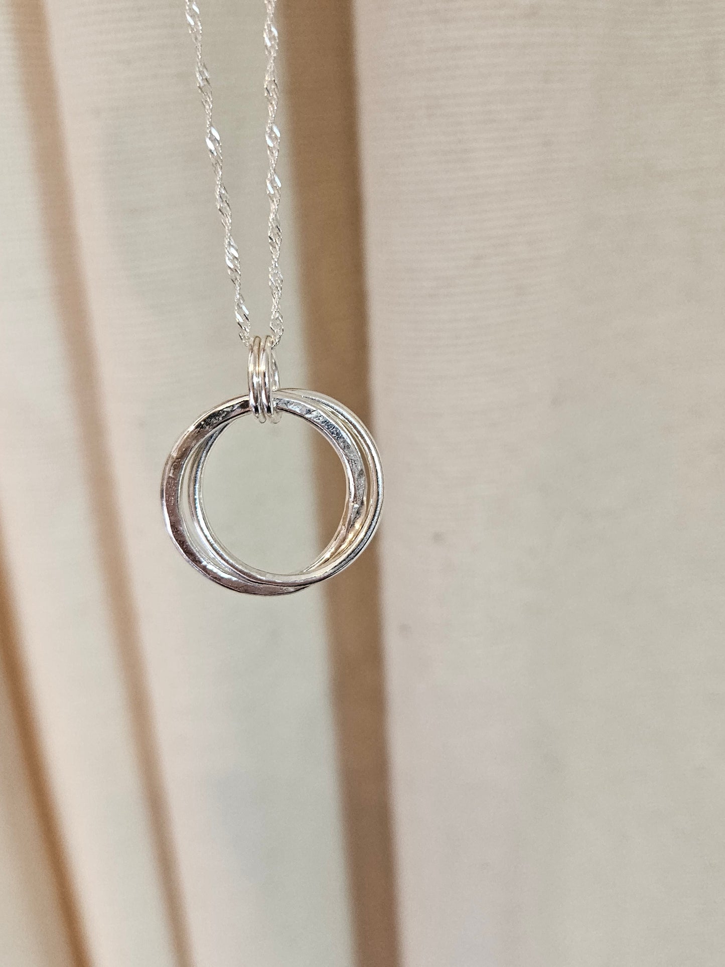 Handmade sterling silver hammered double ring pendant