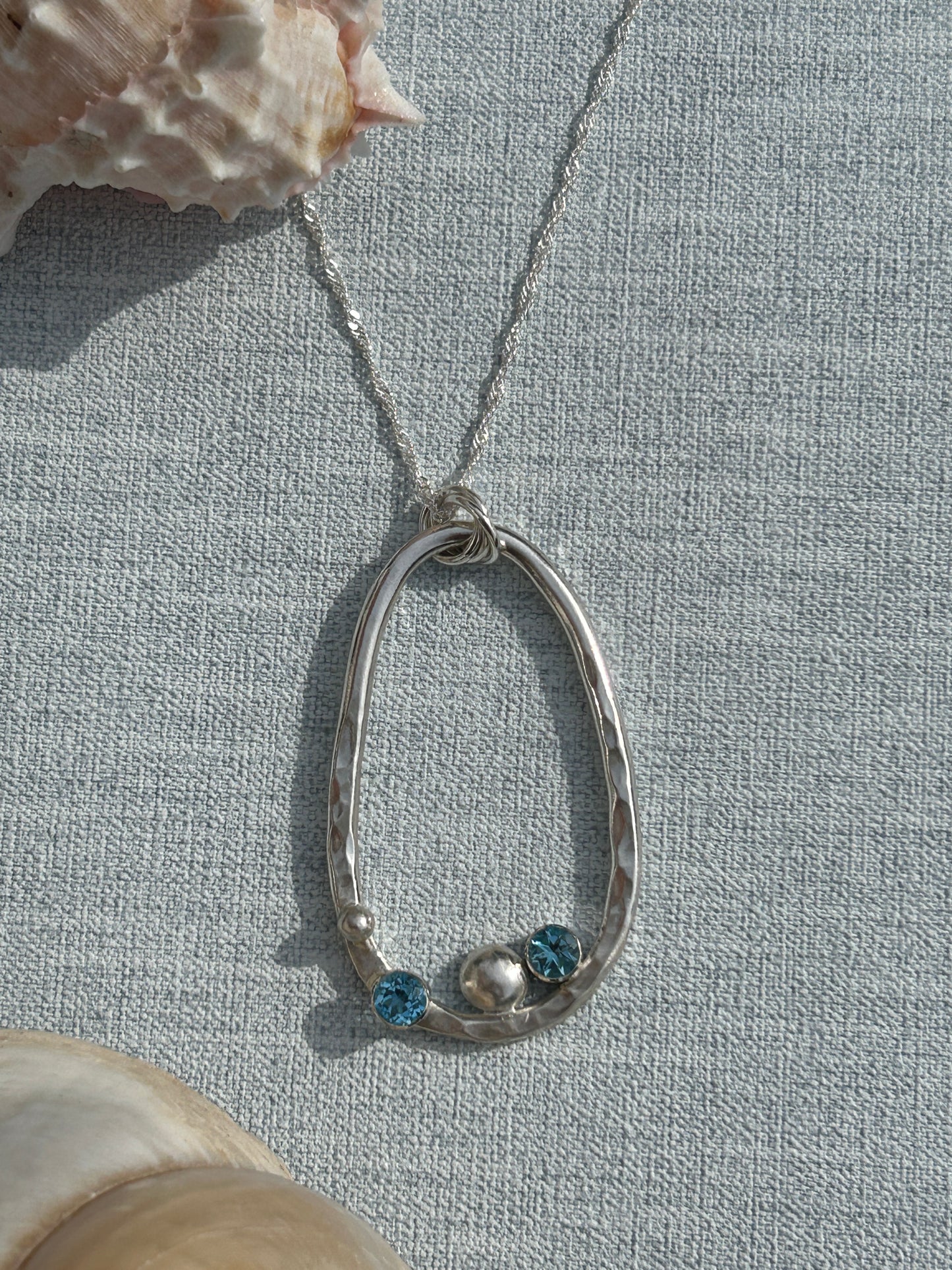 Sterling Silver oval hammed pendant with blue topaz gemstones and a silver nugget