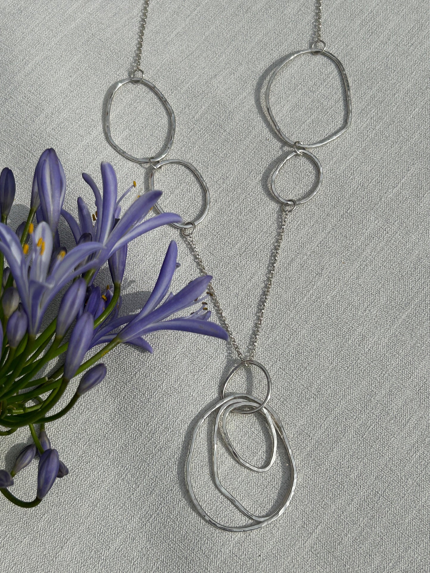 Handmade sterling silver necklace made up of uneven oval and circle shapes