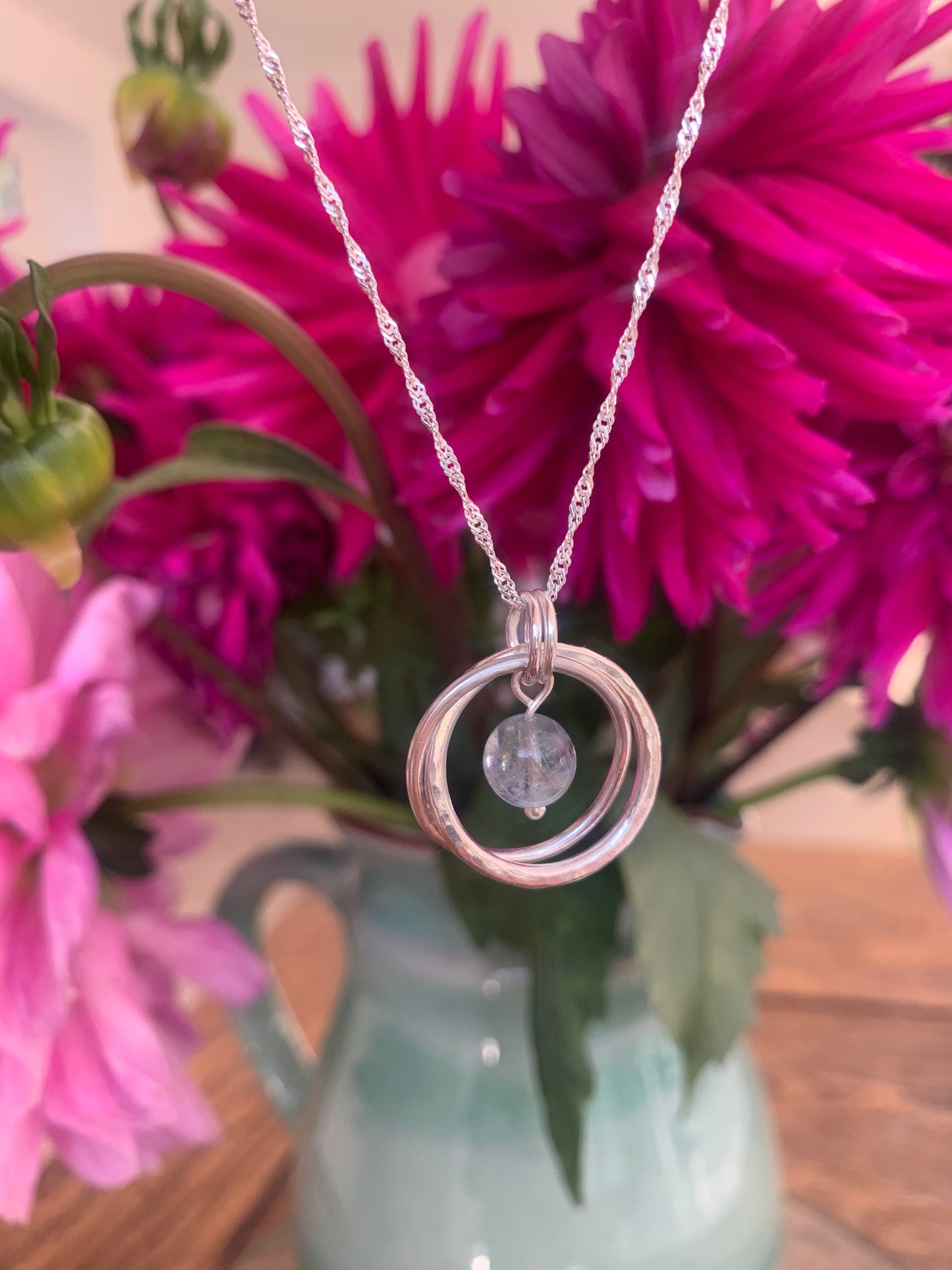 Handmade sterling silver entwined two ring pendant with aquamarine gemstone