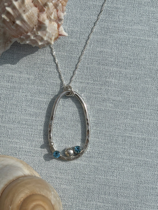 Handmade sterling silver pendant  with blue topaz stones and a silver nugget. Hanging on a silver chain. 